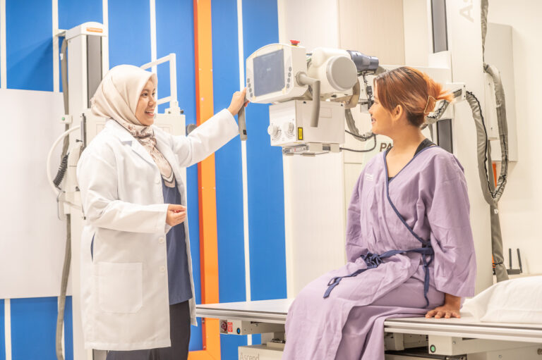 A female Muslim doctor using chest X-ray device with female patient